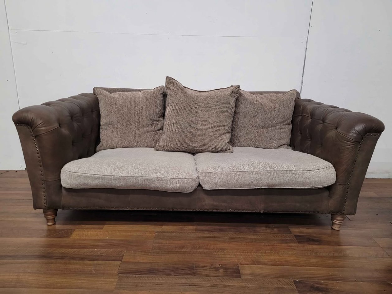 A brown leather Chesterfield sofa with scatter cushions